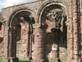 View of the ruins of Lindisfarne Priory. The arcades, especially the pillars with a chevron or zigzag design are like a scaled-down version of those of Durham Cathedral. This is hardly surprising: The priory was refounded in the early twelfth century by the Durham-based community of St Cuthbert, after the building of the Cathedral. It is possible that the same masons worked on both buildings.